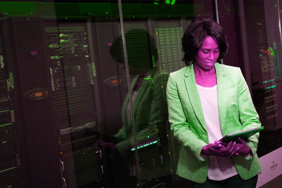 Professionnelle IT inspectant des serveurs dans un datacenter.
